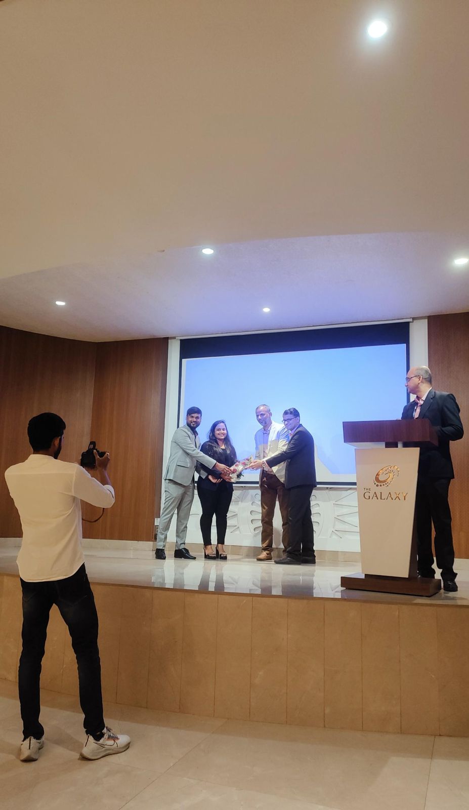 Speakers being welcomed on stage with a bouquet